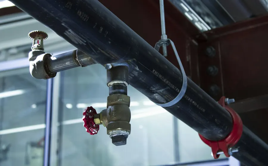 Cañería con llave de paso roja y conexiones de bronce
