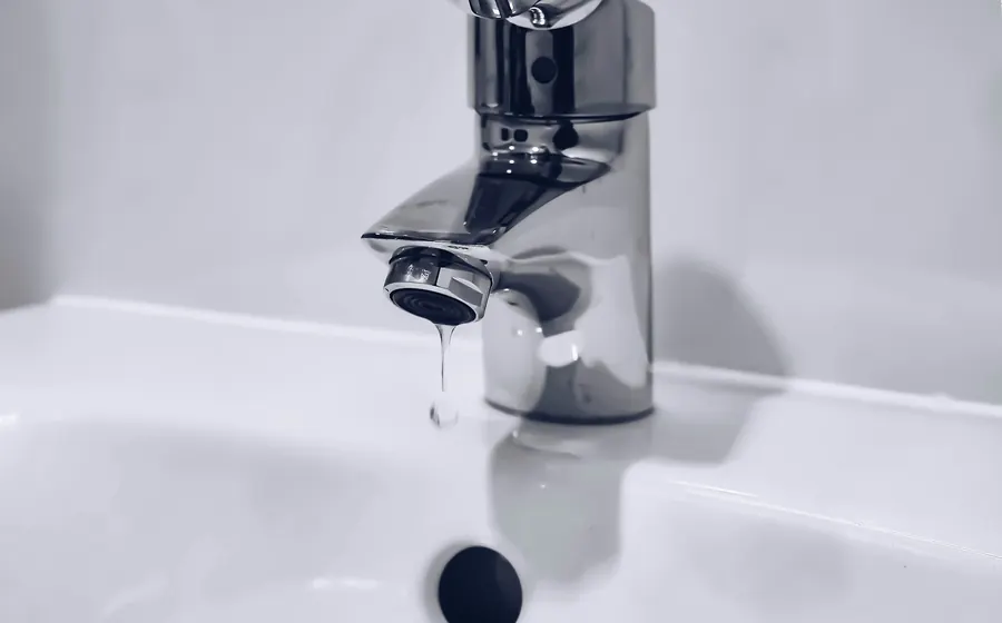 Llave monomando cromada sobre un lavamanos blanco